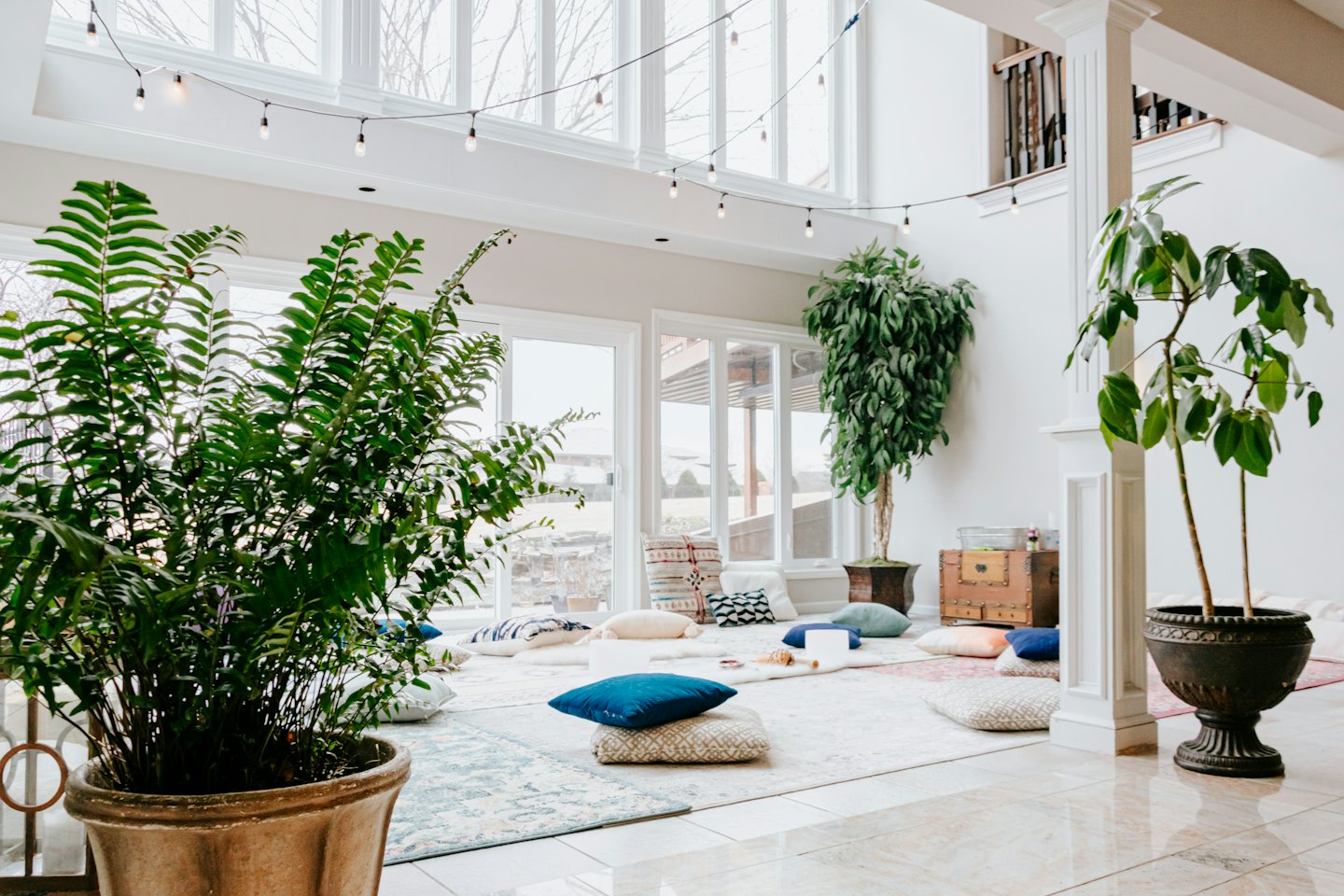 Cozy seating area with floor cushions and plants.